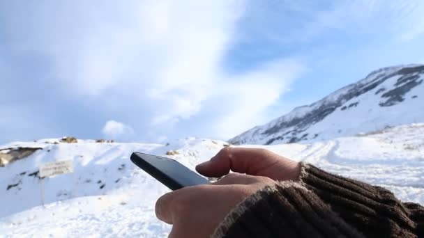 Чоловік шукає щось на смартфоні на вершині гори. Вимикання рукою на мобільному телефоні . — стокове відео