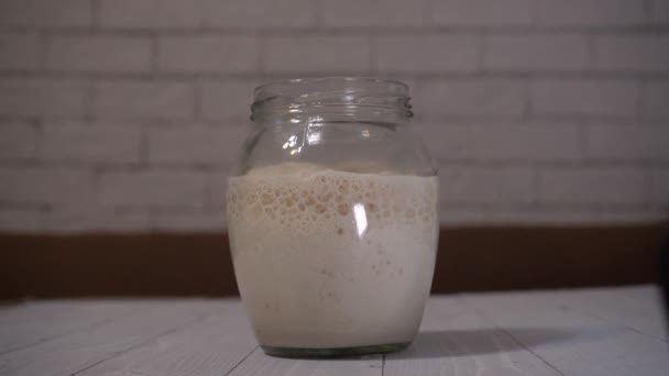 Sneller video voor zelfgemaakte spelt starter gist stijgen in een glazen pot en fermentatie van gist. — Stockvideo