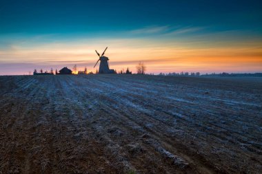 Ahşap fırıldak arkasında sonbahar gündoğumu buzlu