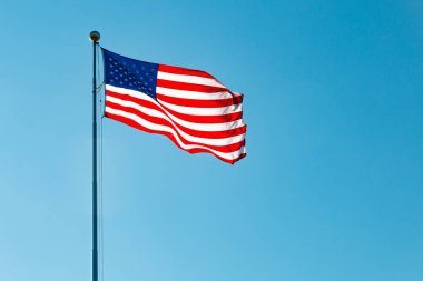 Mavi gökyüzü ile Amerikan bayrağı sallayarak