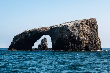 Ventura, Kaliforniya kıyılarında doğu Anacapa Island Kanal Adaları Milli Parkı'nda arka planda bir volkanik kaya oluşumu ile Rock doğal köprü kemer.
