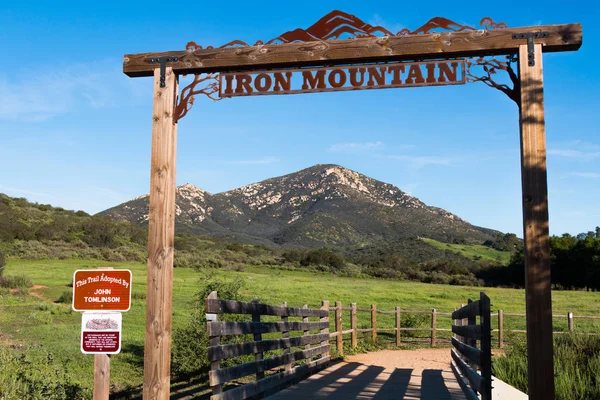 POWAY, CALIFORNIA - MARCH 16, 2017:  Signage at the entrance to the Iron Mountain trail, with a view of Iron Mountain in the background, the second highest peak in the city of Poway.