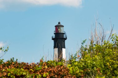 Virginia Beach, Virginia - 11 Temmuz 2017: Yeni Cape Henry yakındaki yeşillik görüldüğü gibi Lighthouse, güney girişinde Chesapeake Körfezi için Fort hikaye askeri üssünde duruyor.