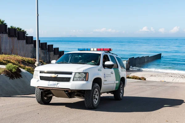stock image SAN DIEGO, CALIFORNIA - NOVEMBER 4, 2017:  A Border Patrol vehicle patrols the international border wall near the ocean at Border Field State Park, the southwesternmost beach in the United States.