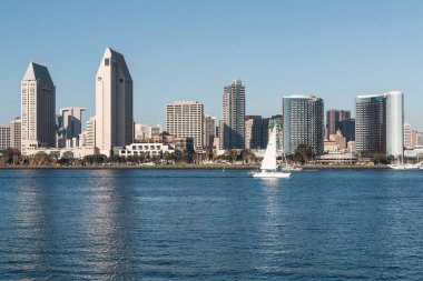 SAN DIEGO, CALIFORNIA - FEBRUARY 4, 2018:  View from Coronado island of the harbor and downtown skyline. The city is home to an active naval fleet and is a popular tourist destination. clipart