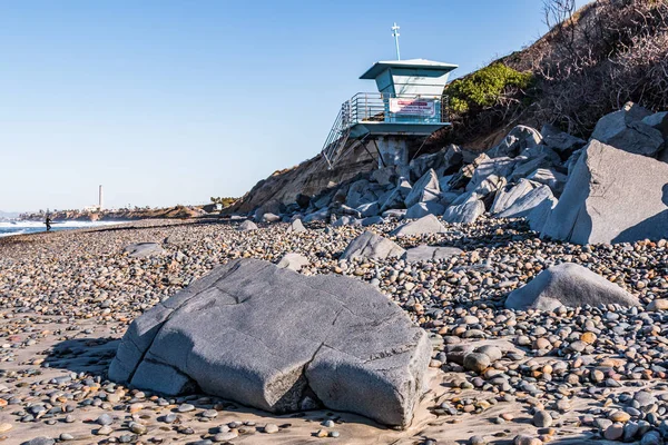 在圣迭戈县南卡尔斯巴德州立海滩上的巨石 石头和救生塔 有地标性的发电厂塔和背景冲浪者 — 图库照片