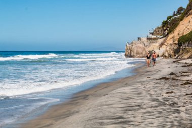 Encinitas, California/ABD - 4 Ekim 2016: Bir erkek ve kadın sörf tahtaları Beacon'ın Beach Encinitas, California devam.