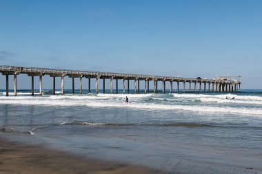 La Jolla Shores San Diego, Kaliforniya, beton araştırma pier yakınındaki insanlar sörf.