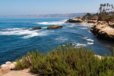 La Jolla Koyu 'ndaki insanların San Diego' daki La Jolla, California 'daki bir uçurumun tepesinden görünüşü. 