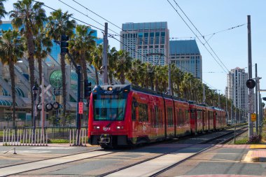 SAN DIEGO, CALIFORNIA / USA - 21 Mart 2020: The Metropolitan Transport System (MTS) ikonik kırmızı tramvay San Diego Kongre Merkezi / Gaslamp Quarter istasyonuna yaklaşırken. 