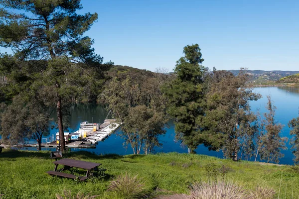 A picnic table sits on a hill overlooking a boat rental dock at Lake Jennings in Lakeside, California and located in San Diego County.