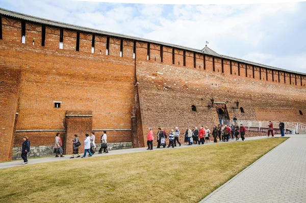 Un grupo de turistas camina a lo largo de la pared del Kremlin de Kolomna desde la puerta del Arcángel Miguel (Mikhailovsky) en la acera — Foto de Stock