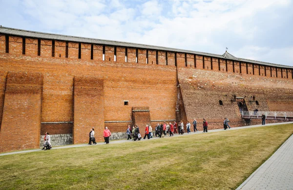 Un grupo de turistas camina a lo largo de la pared del Kremlin de Kolomna desde la puerta del Arcángel Miguel (Mikhailovsky) en la acera — Foto de Stock