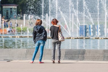 Işık ve müzik çeşme ve Gorki Park ana girişinde. İki genç kız ayağa ve Çeşmede bak