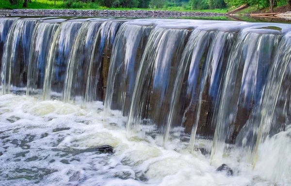 Barragem em um pequeno rio na forma de uma cachoeira — Fotografia de Stock