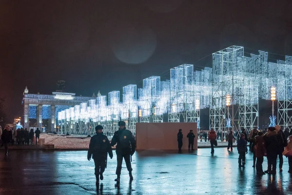 Moskova, Rusya - 1 Ocak 2017: Şenlikli aydınlatma ve bir sürü insan ana Vdnh Avenue yeni yıl arifesinde. Polis ve polis, siluet