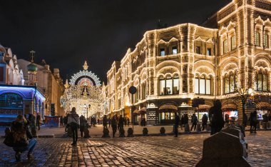 MOSCOW, RUSSIA - January 17, 2017: Red square and the Main Department store (GUM) and Nikolskaya street with Christmas illumination winter evening  clipart
