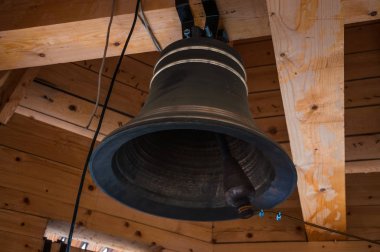 New bell in the bell tower of a wooden Church clipart