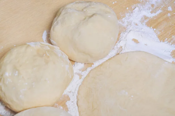 Raw wheat yeast dough rolled out into flat cakes on a table — Stock Photo, Image
