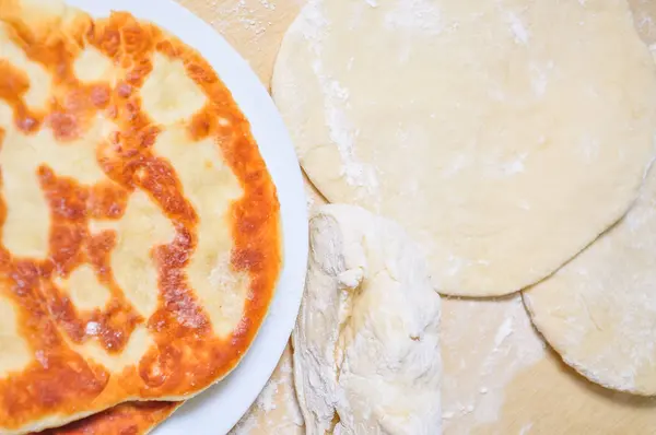 Ready fried wheat pitas and raw yeast dough — Stock Photo, Image