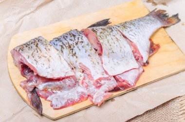 Çiğ balık IDE doğrama tahtası üzerinde yemek pişirmek için parçalar halinde kesilmiş