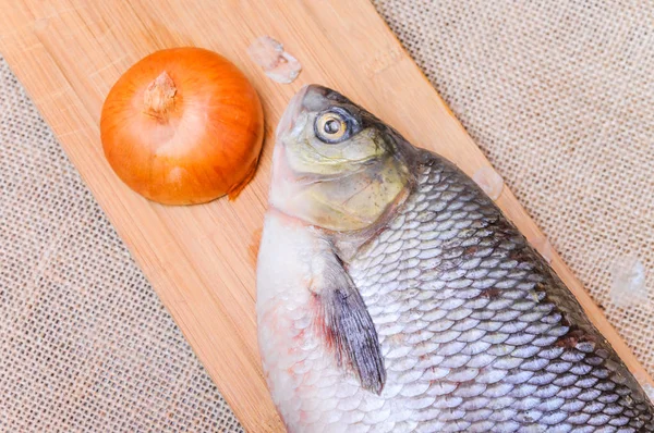 Peixe cru em uma tábua de corte — Fotografia de Stock