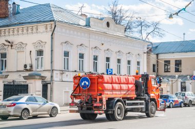 Moskova, Rusya - 10 Nisan 2015: Sulama temizlik araba Kamaz. Trafik polisi, Alexander Solzhenitsyn sokak alay yönetimi. Eski şehir Zimins konak XIX yüzyılın başında