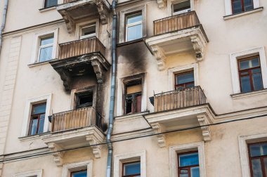 Yangından sonra evin cephe. Yanık daire çevresinde kurum duvarından kararmış. Pencere ve balkon alevler zarar