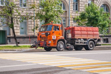 Moskova, Rusya - 1 Temmuz 2019: Kamaz araba sulama makinesi ve su tankı kuru yaz havasında asfaltı yıkıyor