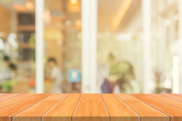 在模糊的背景前的木板空桌子上.在咖啡店里，透视褐色的木料在模糊的地方，可用于展示或装饰你的产品。. — 图库照片