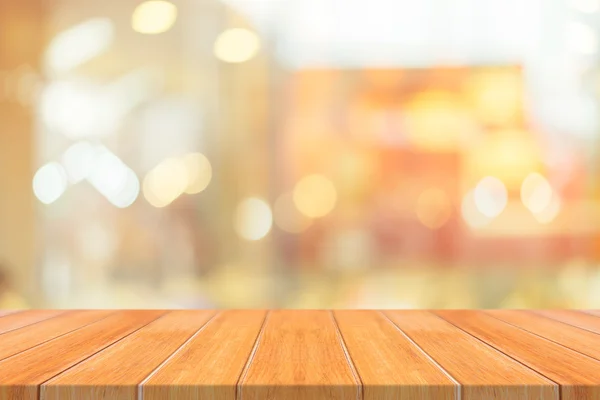 在模糊的背景前的木板空桌子上.在咖啡店里，透视褐色的木料在模糊的地方，可用于展示或装饰你的产品。. — 图库照片