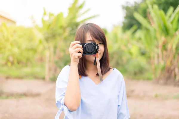 微笑的年轻女士使用的照相机在公园户外拍张照片 — 图库照片