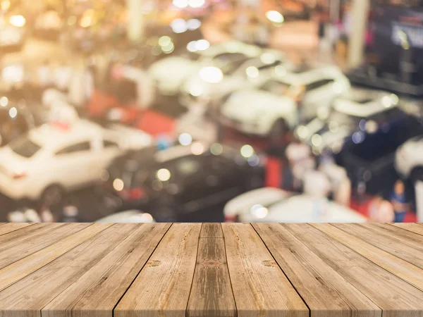Placa de madeira mesa vazia fundo borrado. Perspectiva de madeira marrom sobre desfoque carro showroom - pode ser usado para exibir ou montar seus produtos. Preparem-se para a exibição do produto. Imagem de filtro vintage . — Fotografia de Stock