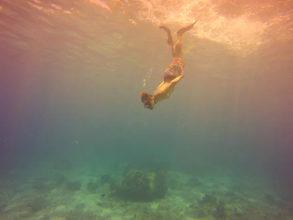Selfie subaquático tiro com jovem mergulhando em uma respiração segurar em um mar tropical sobre fundo arenoso. Mar azul profundo. Tiro de ângulo largo. Imagem filtrada vintage . — Fotografia de Stock