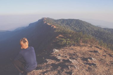Adam Tayland'da renkli yaz boyunca dağlarda harika manzara izlerken tepenin üstünde. Vintage filtre uygulanmış görüntü.