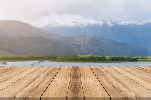 Holzbrett leerer Tisch vor verschwommenem Hintergrund. Perspektive braun Holz Tisch über verschwommenem See im Wald Berg Hintergrund - kann verwendet werden Attrappe für die Anzeige oder Montage Ihrer Produkte. — Stockfoto