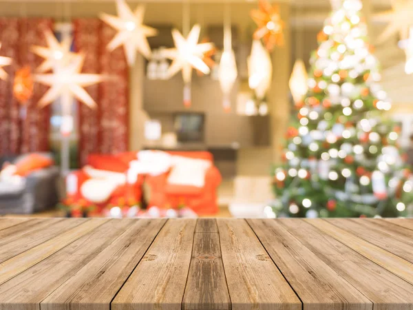Tomt bord i tre, med utydelig bakgrunn. Perspektiv brunt trebord over uklare juletre og bakgrunn fra peiser kan brukes som modell for montasjeprodukters visning eller utforming stockbilde