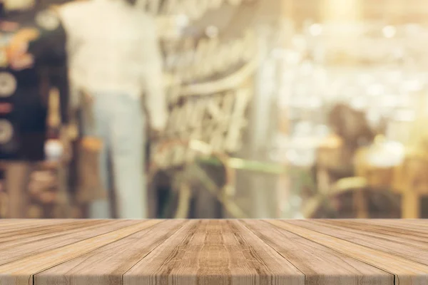 Holzbrett leere Tischplatte auf verschwommenem Hintergrund. Perspective braunen Holztisch über Unschärfe in Café-Hintergrund - kann verwendet werden, um Attrappe für Montage Produkte Anzeige oder Design Schlüssel visuelles Layout. — Stockfoto