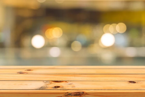 Plateau vide en bois sur fond flou. Perspective table en bois marron sur flou dans le fond du café peut être utilisé modèle pour l'affichage des produits de montage ou la conception mise en page visuelle clé. — Photo