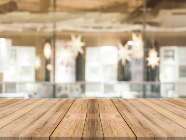 Ahşap tahta boş masa üstü bulanık arkaplan. Kahve dükkanının arka planındaki bulanıklık üzerine perspektif kahverengi ahşap masa - montaj ürünleri görüntüleme veya tasarım anahtar görsel düzeni için kullanılabilir.