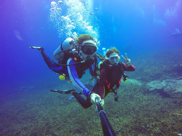 Selfie subacqueo di immersioni con bastone selfie. Mare blu profondo. Colpo grandangolare . — Foto Stock