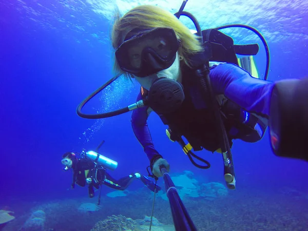 Selfie subacqueo di immersioni con bastone selfie. Mare blu profondo. Colpo grandangolare . — Foto Stock