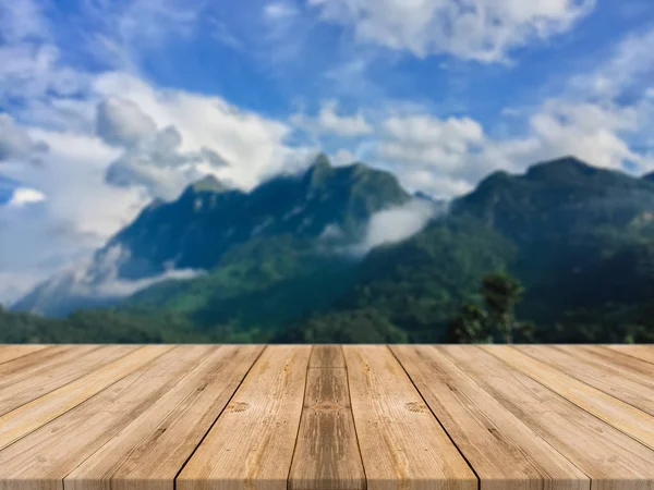 Holzbrett leerer Tisch vor verschwommenem Hintergrund. Perspektive braun Holztisch über verschwommener Berglandschaft Hintergrund - kann zur Anzeige oder Montage Ihrer Produkte verwendet werden. — Stockfoto