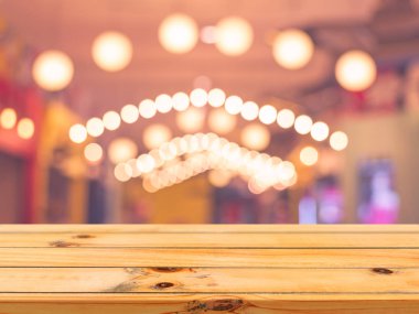 Ahşap tahta boş masa üstü bulanık arkaplan. Kahve dükkanının arka planındaki bulanıklık üzerine perspektif kahverengi ahşap masa - montaj ürünleri görüntüleme veya tasarım anahtar görsel düzeni için kullanılabilir.
