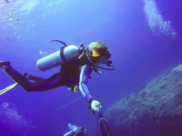 Selfie subacqueo di immersioni con bastone selfie. Mare blu profondo. Colpo grandangolare . — Foto Stock