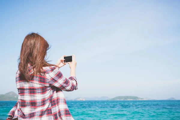 Takaisin näkymä nainen ottaa valokuvan älypuhelimen kamera horisontissa rannalla . — kuvapankkivalokuva