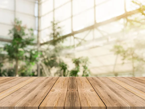 Tablero de madera mesa vacía en frente de fondo borroso. Mesa de madera marrón perspectiva sobre los árboles borrosos en el fondo del bosque - se puede utilizar la maqueta para mostrar o montar sus productos. temporada de primavera . — Foto de Stock