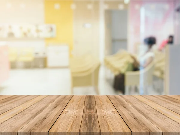 Tablero de madera mesa vacía en frente de fondo borroso. Mesa de madera marrón perspectiva sobre la sala de desenfoque en el fondo del hospital - se puede utilizar la maqueta para mostrar o montar sus productos . —  Fotos de Stock