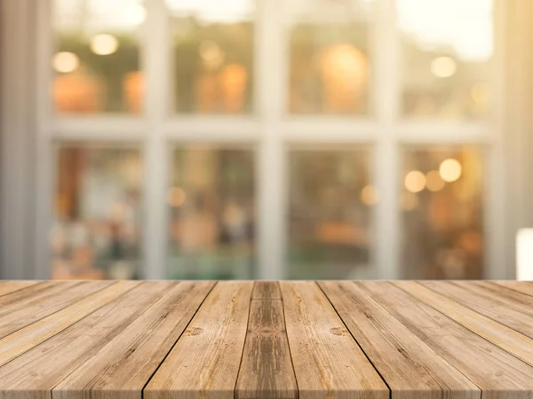 Tablero de madera mesa vacía sobre fondo borroso. Mesa de madera marrón perspectiva sobre desenfoque en el fondo de la cafetería - se puede utilizar la maqueta para la exhibición de productos de montaje o diseño diseño diseño visual clave. Imagen de stock