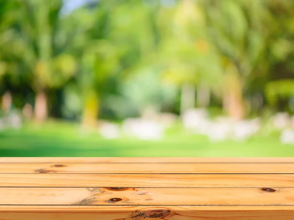 Placa de madeira mesa vazia na frente do fundo borrado. Mesa de madeira marrom perspectiva sobre árvores borrão no fundo da floresta - pode ser usado simular para exibir ou montar seus produtos. estação de primavera . — Fotografia de Stock